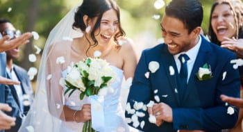 Happy couple just married being showered with flower petals